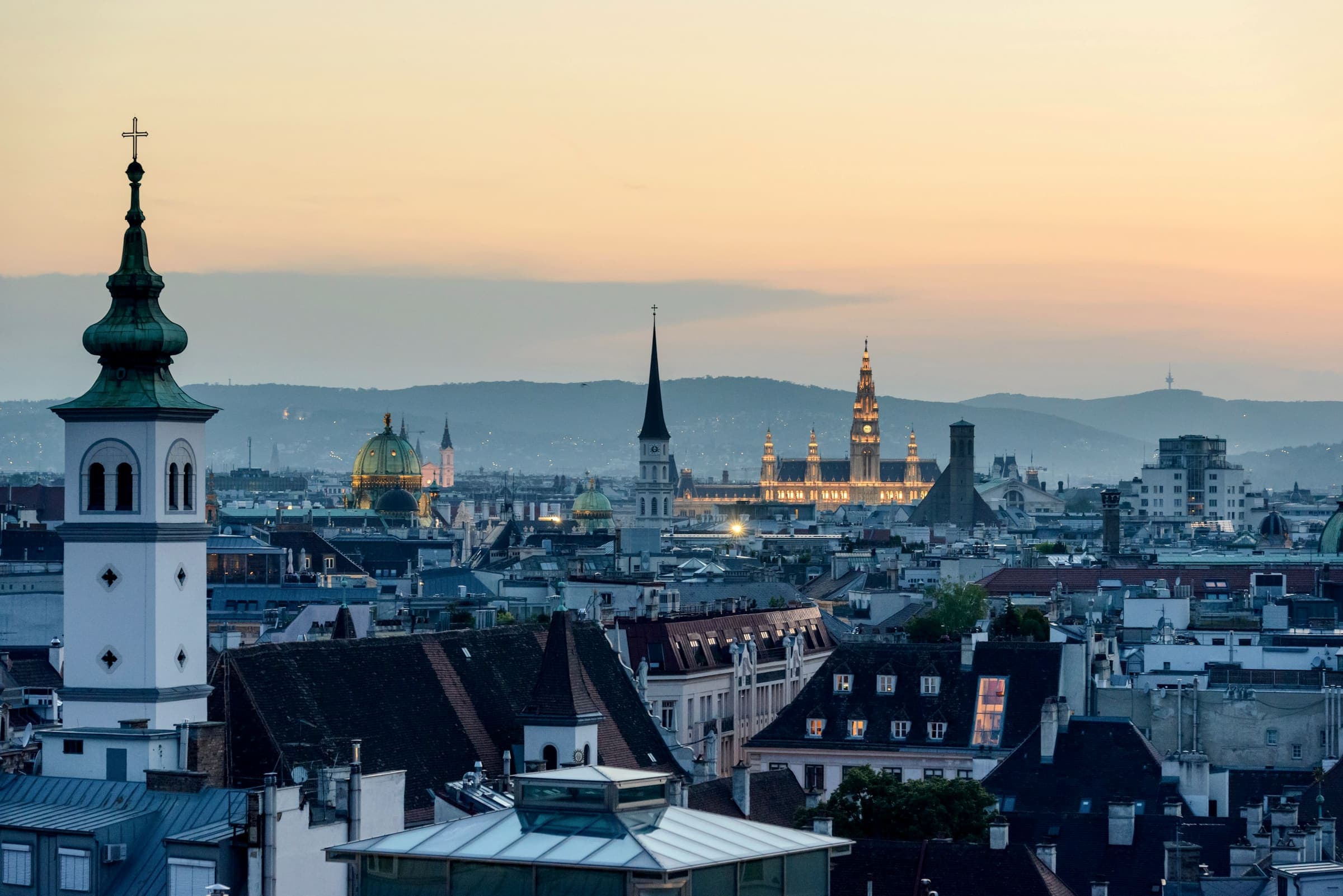 Wien am Abend, Blick über die Dächer der Innenstadt zum beleuchteten Rathaus